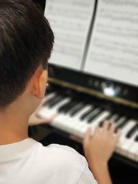 Rear view of man playing piano