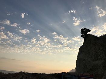 Low angle view of silhouette cliff against sky during sunset