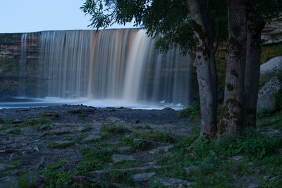 Scenic view of waterfall against trees