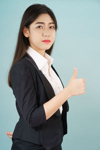 Portrait of a young woman against gray background