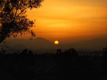 Scenic view of silhouette landscape against orange sky