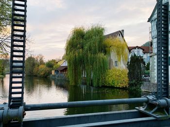 River amidst trees and buildings against sky