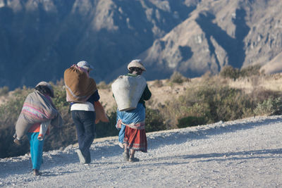 Rear view of family walking on dirt road