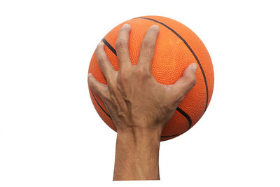 Cropped image of hand holding ball over white background