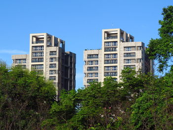 Low angle view of buildings against clear blue sky