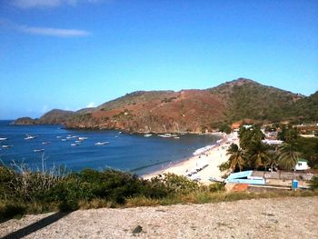 Scenic view of sea and mountains against blue sky