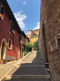 Alley amidst buildings in town against sky