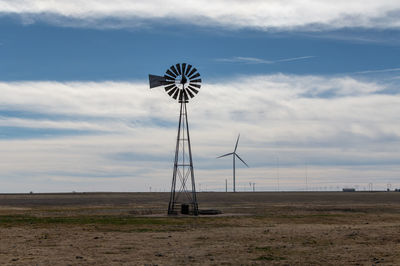 Windmill on the prairie with wind generator in the background