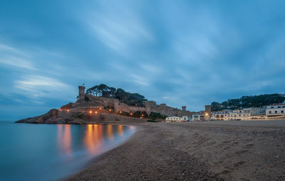 View of buildings by sea against sky