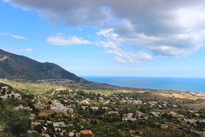 Aerial view of townscape by sea against sky