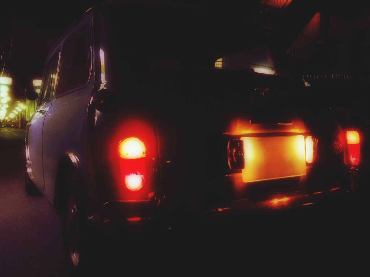 ILLUMINATED CARS AT NIGHT SEEN THROUGH CAR WINDSHIELD AT BUS