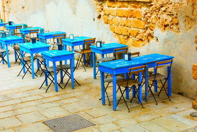 Empty chairs and tables against wall