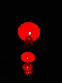 Low angle view of illuminated lantern against black background