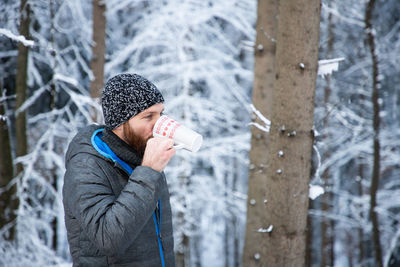 Midsection of man holding ice cream in forest