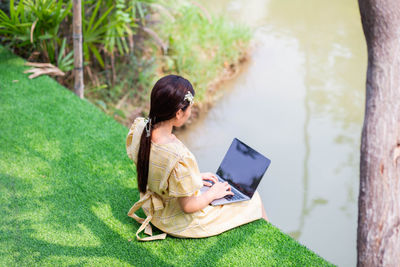 Man using mobile phone while sitting on grass