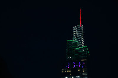 Low angle view of illuminated buildings against sky at night