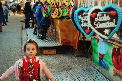 Cute girl standing in street market in city