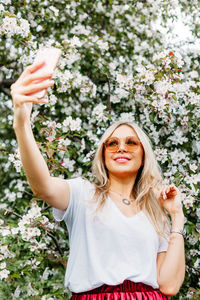 Portrait of a young woman smiling while standing on plants