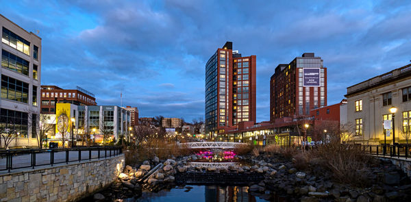 Bridge over canal amidst buildings against sky at dusk