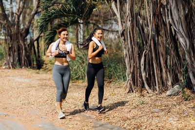Full length of smiling young woman in forest