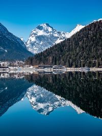 Scenic view of lake and mountains against blue sky