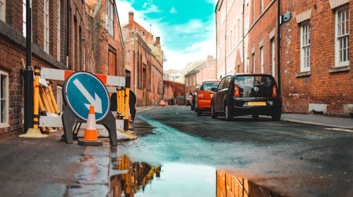 Road by buildings against sky in city