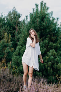 Full length of woman standing against trees