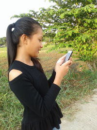 Young woman using mobile phone in park