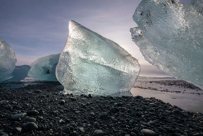 Surface level of frozen sea and rocks against sky