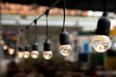 Close-up of light bulb hanging from ceiling