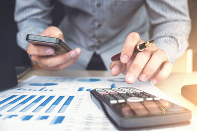 Midsection of businessman working at table