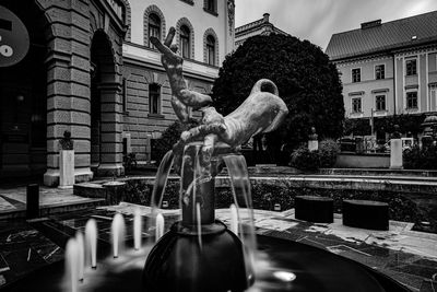 Statue against buildings in city