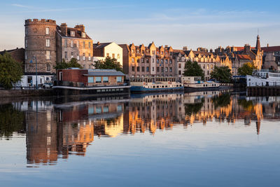 Reflection of buildings in river against sky in the shore, leith, edinburgh