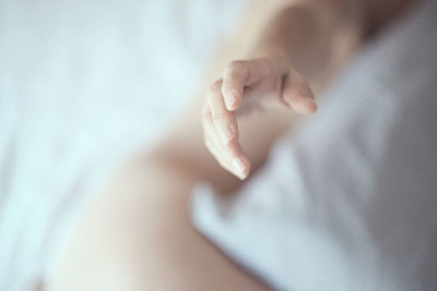 Close-up of hand on bed at home