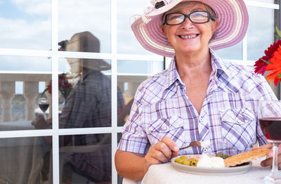 Portrait of smiling senior woman eating breakfast