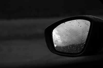 Close-up of raindrops on side-view mirror