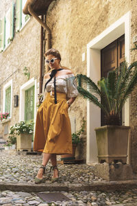 Portrait of young woman standing against plants