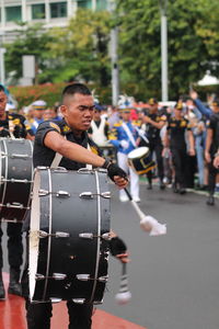 Other men play the drums in a marching band