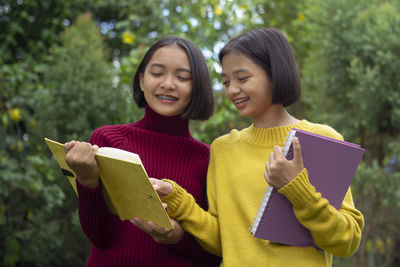 Happy young woman holding book