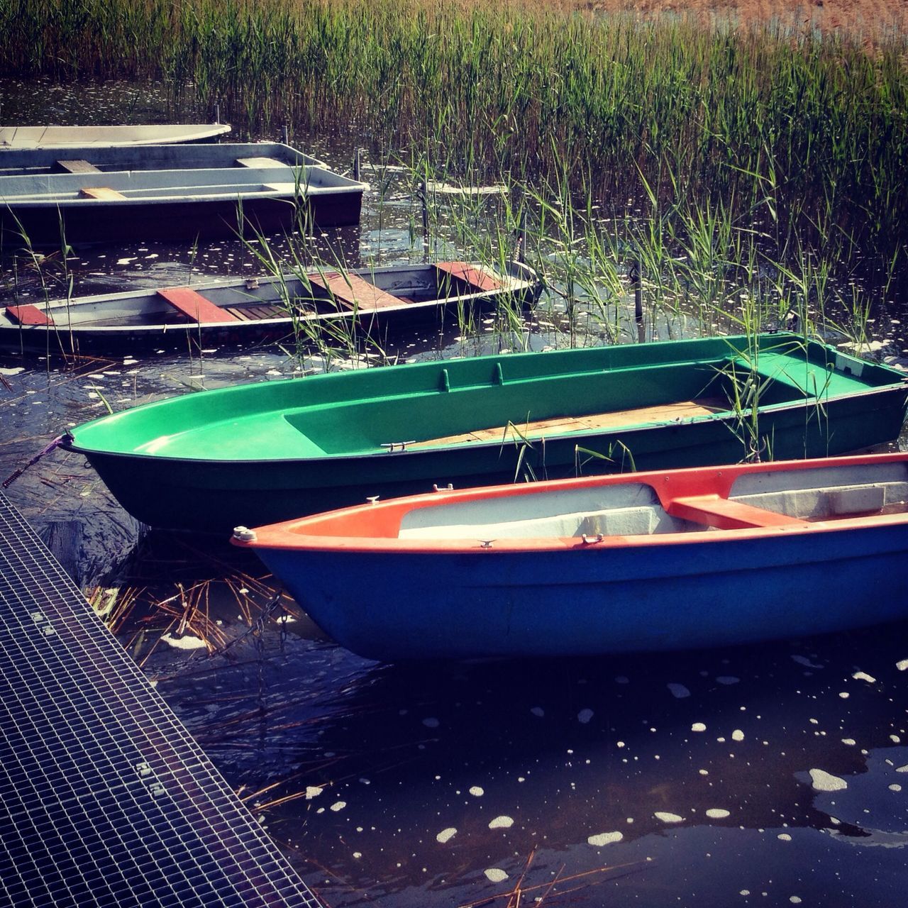 transportation, nautical vessel, mode of transport, boat, moored, water, high angle view, outdoors, no people, reflection, day, absence, travel, sunlight, rowboat, nature, lake, river, land vehicle, grass