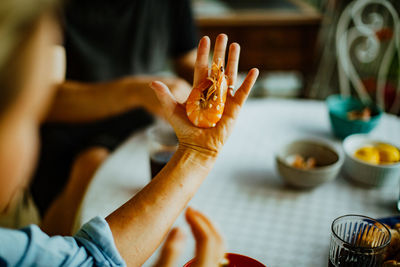 Midsection of people holding shrimp