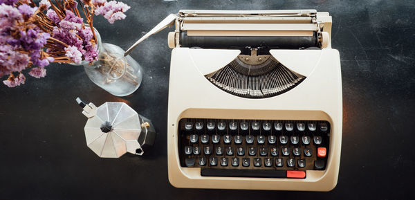 High angle view of typewriter and vase on table