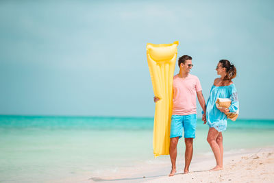 Women standing on beach against sky