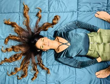 High angle view of woman lying on bed