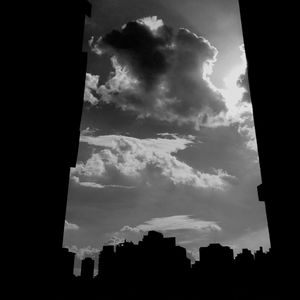 Low angle view of buildings against cloudy sky