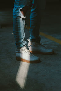 Low section of man standing on road