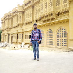 Full length of man standing against building