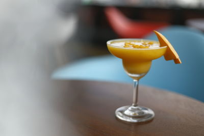 Close-up of a mango smoothie drink on a cocktail glass at a bar