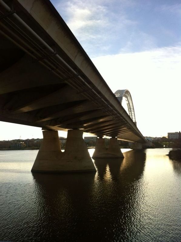 bridge - man made structure, connection, built structure, architecture, bridge, engineering, water, river, transportation, sky, waterfront, low angle view, suspension bridge, architectural column, reflection, support, long, cloud - sky, arch bridge, arch