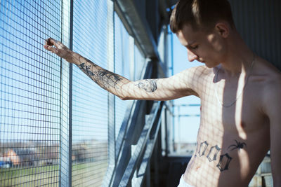 Young man standing by window